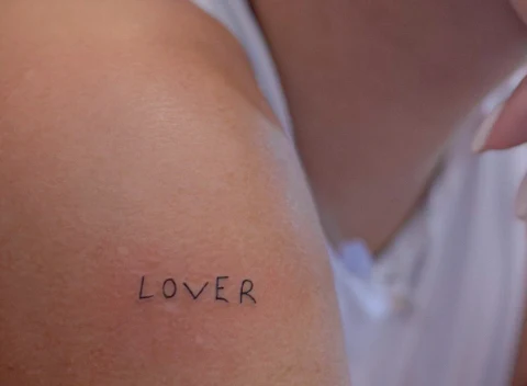Kaligrafska tetovaža „Lover” na ramenu
