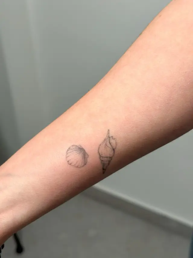 Fine line tetovaža školjke i kamenčića na podlaktici, healed